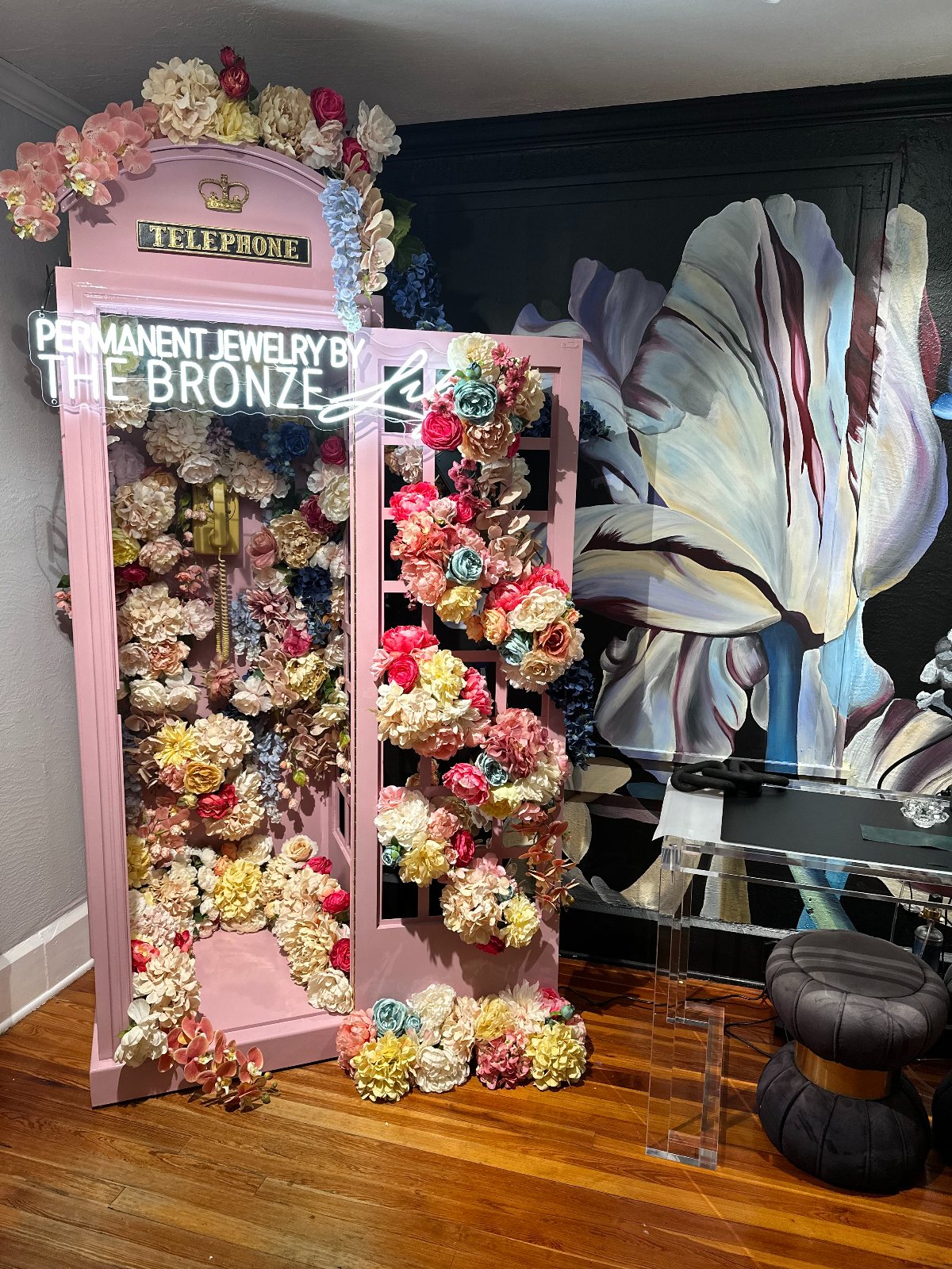 Pink telephone booth and neon tulip mural — a favorite bachelorette photo stop near — The Bronze Lily, St. Petersburg, FL